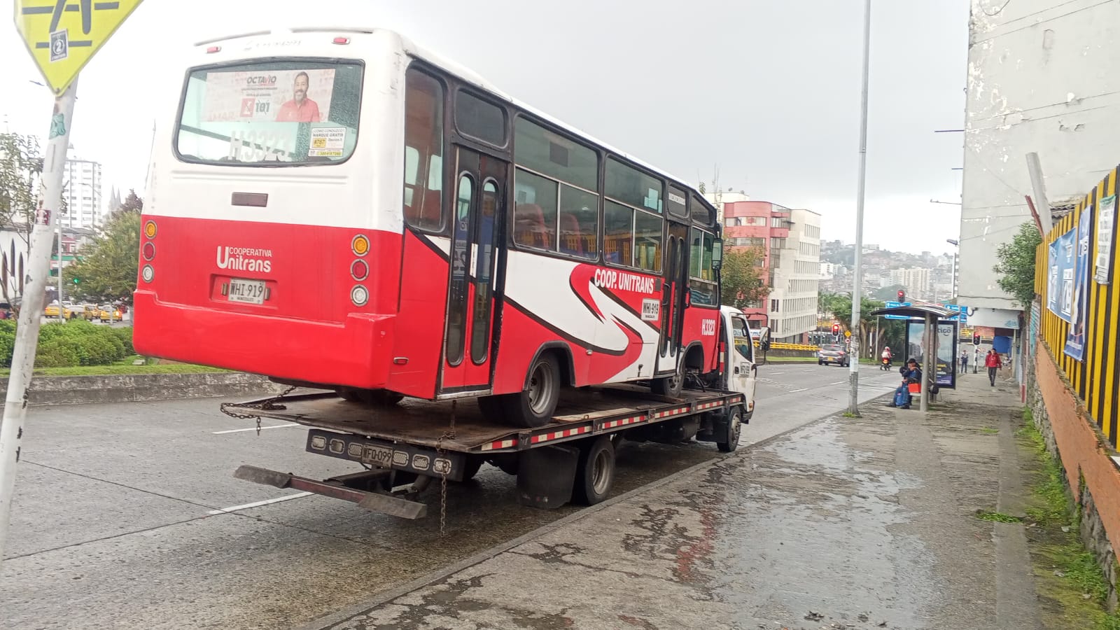 Grúa Palotieso remolcando bus urbano en vía pública